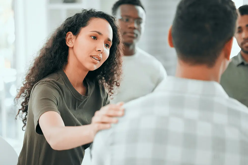 A woman comforting a man in therapy during a Dual Diagnosis Treatment Program