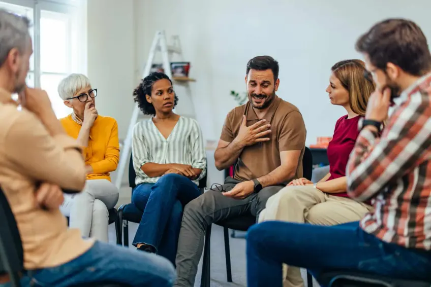 man sharing in group therapy session