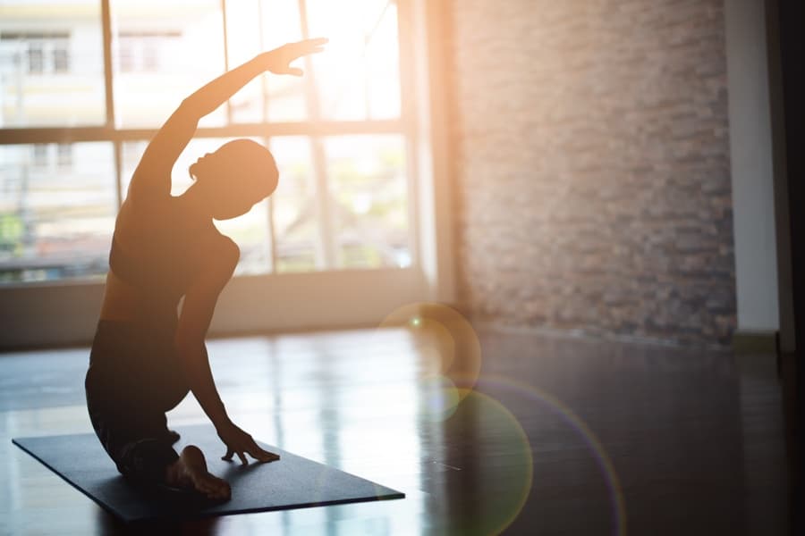 woman stretching and practicing yoga in a holistic wellness setting