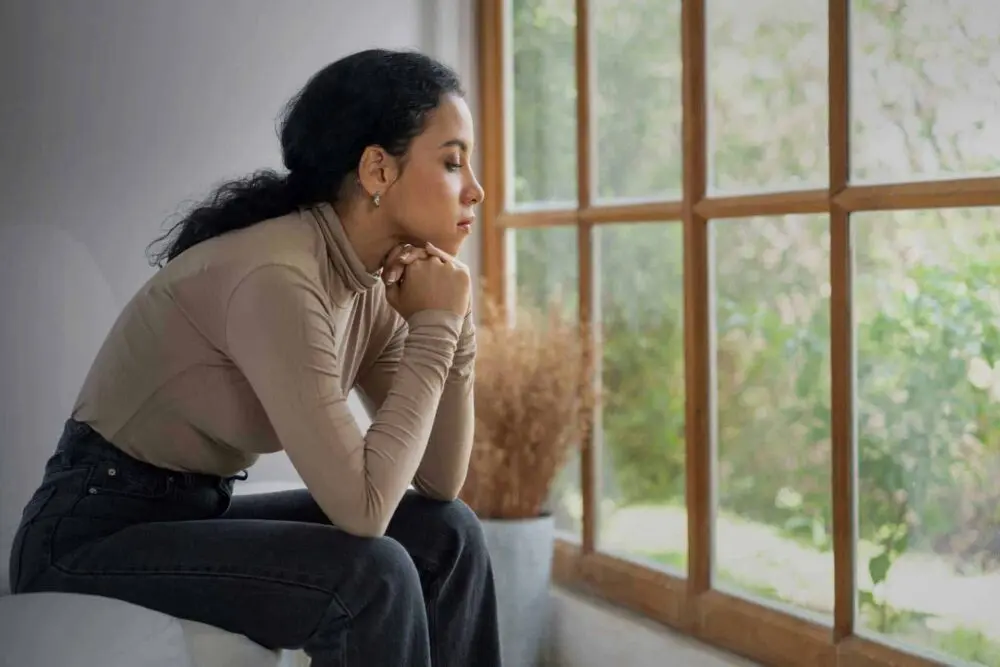 Woman staring out the window considering heroin metabolism and effects