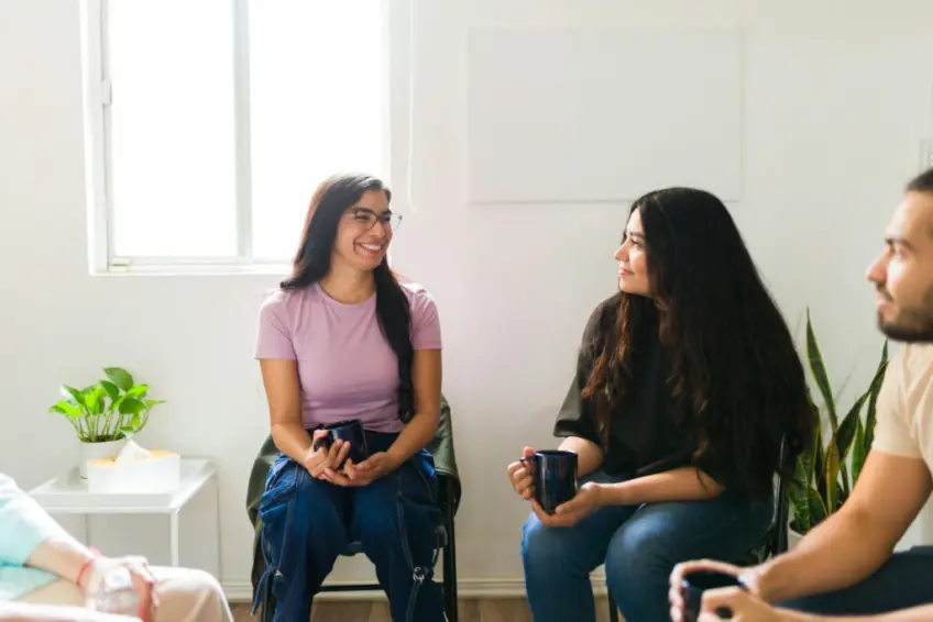 a-group-of-individuals-smiling-in-therapy
