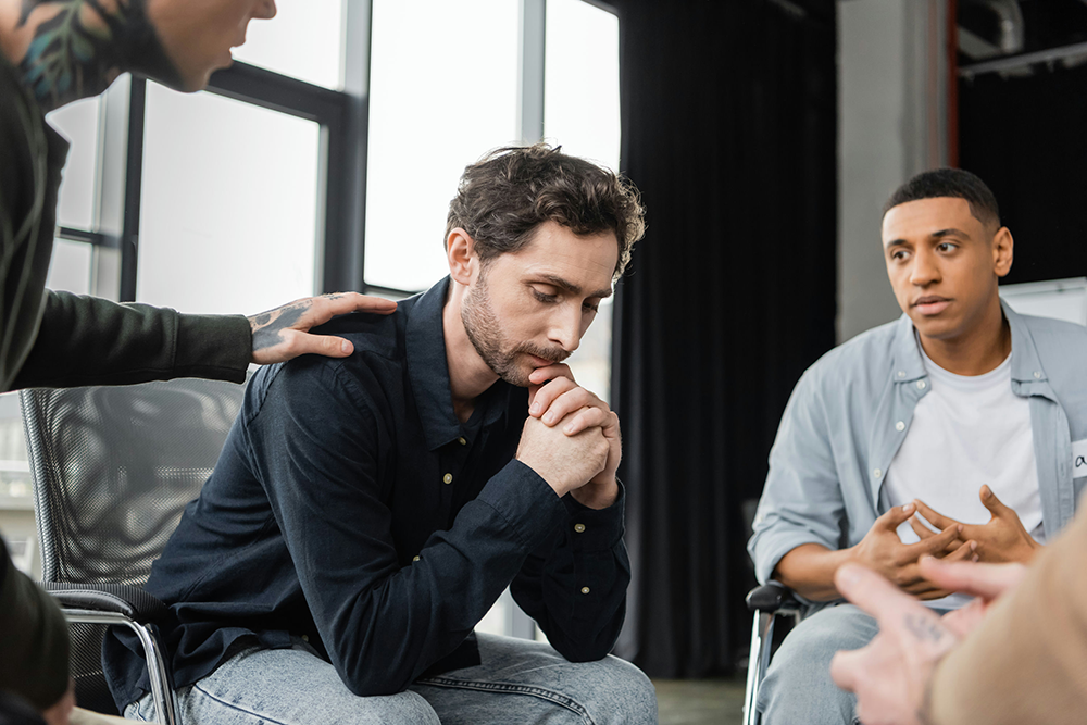 group of men discussing topics together in addiction group therapy