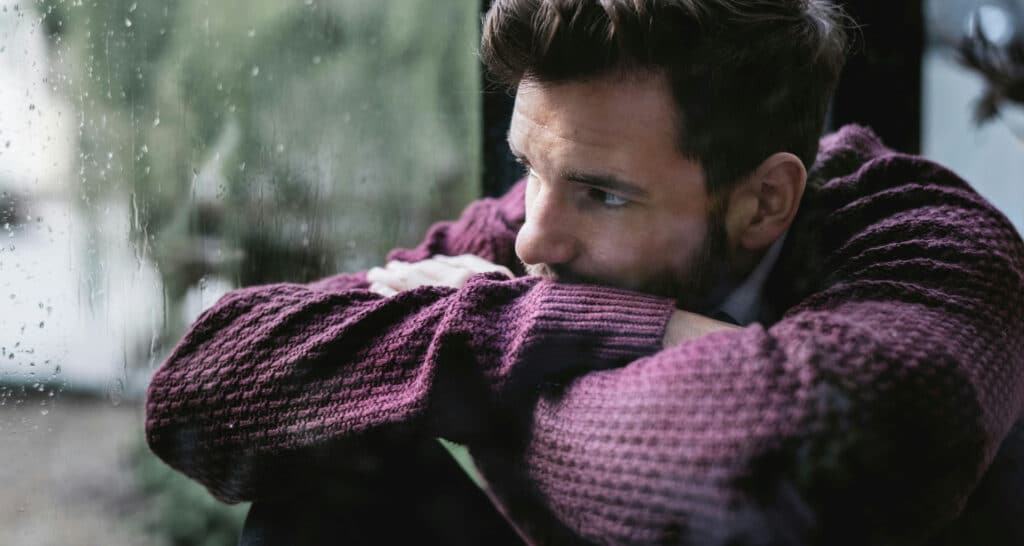 man staring out window, thinking about how long alcohol stays in his system