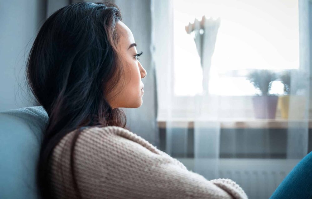 Pensive woman looking outside, concerned about heroin detection time